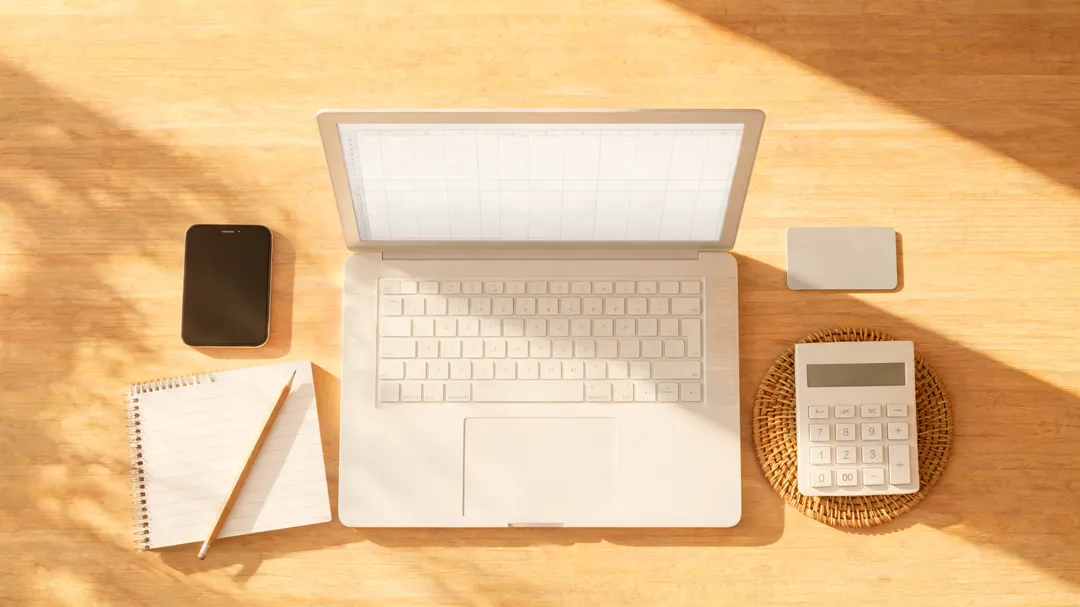 Cinematic top-down desk scene with laptop spreadsheet layout